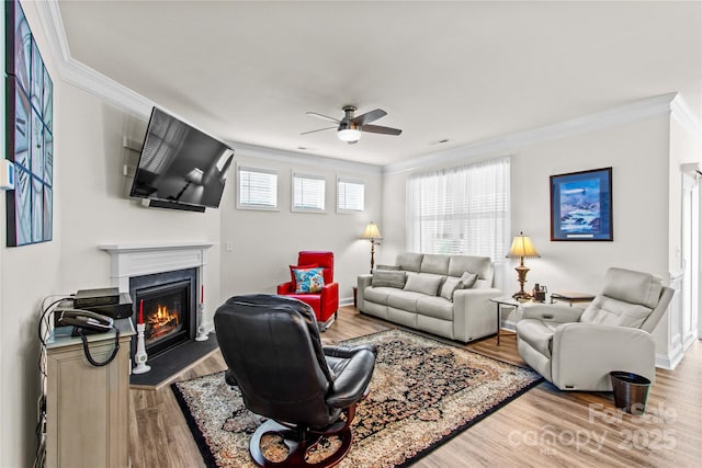117 Cup Chase Dr, Mooresville, NC 28115 - living area featuring crown molding, a ceiling fan, a fireplace with flush hearth, and wood finished floors