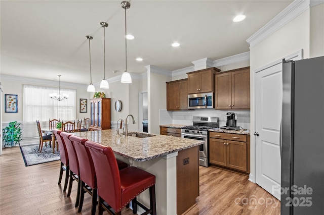 117 Cup Chase Dr, Mooresville, NC 28115 - kitchen with appliances with stainless steel finishes, crown molding, light wood-style flooring, tasteful backsplash, and light stone countertops