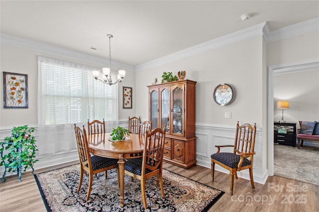 117 Cup Chase Dr, Mooresville, NC 28115 - dining room featuring light wood-style floors, a chandelier, ornamental molding, and wainscoting