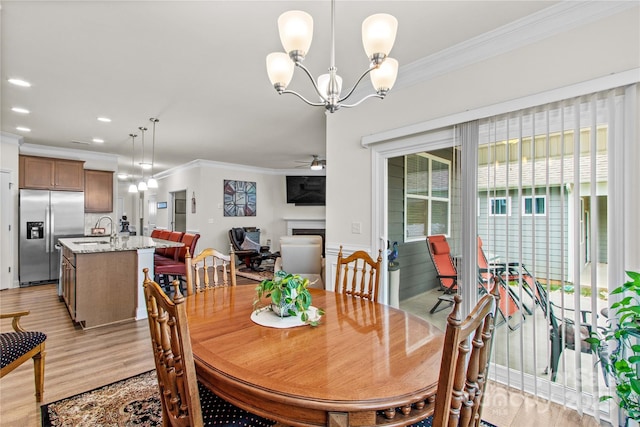117 Cup Chase Dr, Mooresville, NC 28115 - dining room with crown molding, a fireplace, light wood-type flooring, ceiling fan, and a chandelier