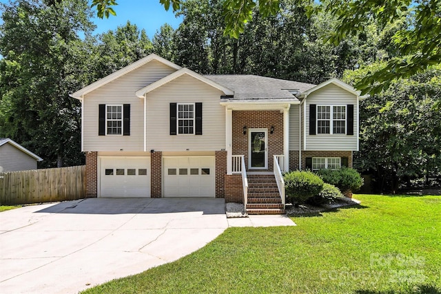 824 17th Avenue Dr SE, Hickory, NC 28602 - bi-level home with brick siding, a garage, driveway, and view of wooded area