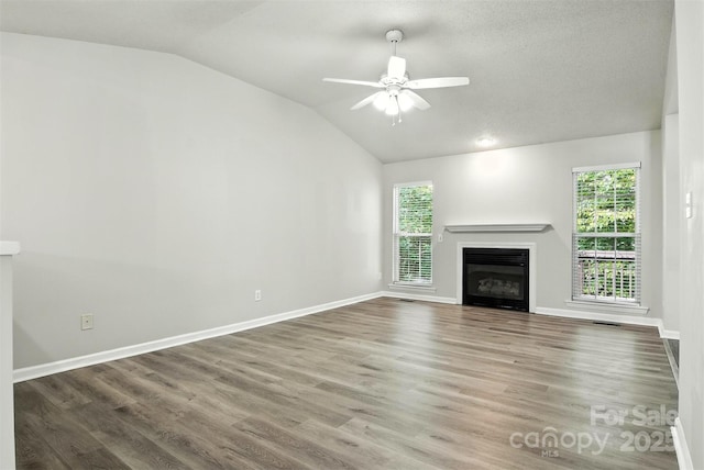 824 17th Avenue Dr SE, Hickory, NC 28602 - unfurnished living room featuring vaulted ceiling, a glass covered fireplace, a ceiling fan, and wood finished floors