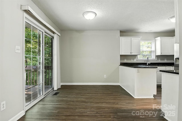 824 17th Avenue Dr SE, Hickory, NC 28602 - kitchen with a textured ceiling, dark countertops, white cabinetry, dark wood-type flooring, and fridge with ice dispenser