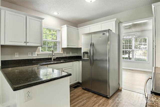 824 17th Avenue Dr SE, Hickory, NC 28602 - kitchen featuring stainless steel refrigerator with ice dispenser, a textured ceiling, wood finished floors, white cabinetry, and a peninsula