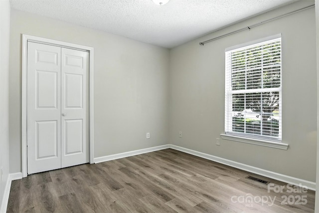 824 17th Avenue Dr SE, Hickory, NC 28602 - unfurnished bedroom featuring wood finished floors, a closet, and a textured ceiling