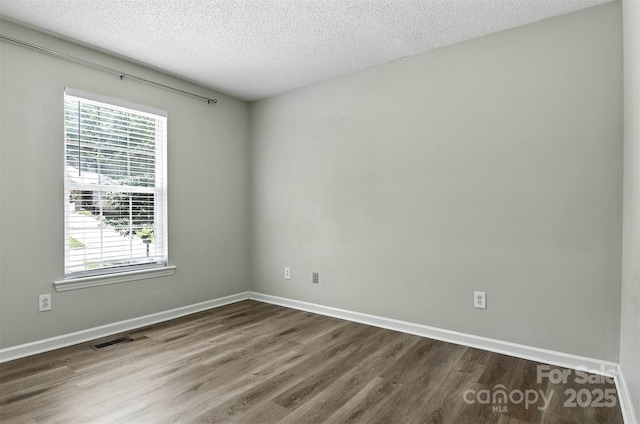 824 17th Avenue Dr SE, Hickory, NC 28602 - empty room featuring dark wood-style flooring, plenty of natural light, and a textured ceiling
