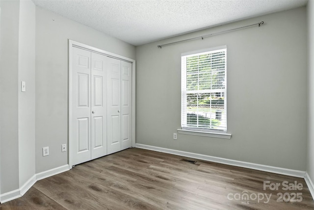 824 17th Avenue Dr SE, Hickory, NC 28602 - unfurnished bedroom with wood finished floors, a textured ceiling, and a closet