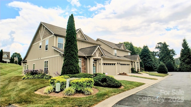 22 Florian Ln, Fletcher, NC 28732 - view of side of home with an attached garage, a lawn, concrete driveway, and board and batten siding
