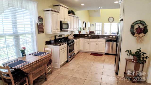 22 Florian Ln, Fletcher, NC 28732 - kitchen with appliances with stainless steel finishes, dark countertops, light tile patterned flooring, white cabinetry, and recessed lighting