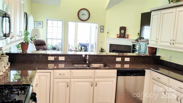 22 Florian Ln, Fletcher, NC 28732 - kitchen featuring appliances with stainless steel finishes, open floor plan, dark stone counters, white cabinetry, and a fireplace