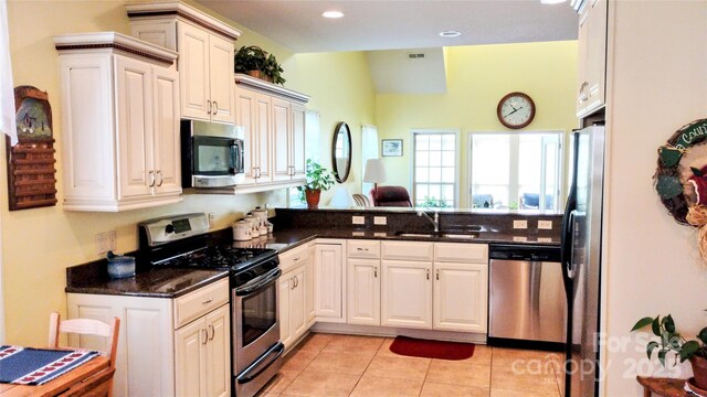 22 Florian Ln, Fletcher, NC 28732 - kitchen featuring appliances with stainless steel finishes, light tile patterned floors, a peninsula, dark stone counters, and recessed lighting