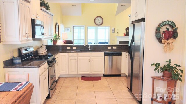 22 Florian Ln, Fletcher, NC 28732 - kitchen with appliances with stainless steel finishes, a peninsula, light tile patterned flooring, and white cabinets