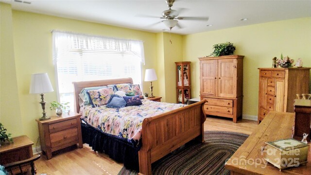 22 Florian Ln, Fletcher, NC 28732 - bedroom with multiple windows, light wood-style flooring, and a ceiling fan