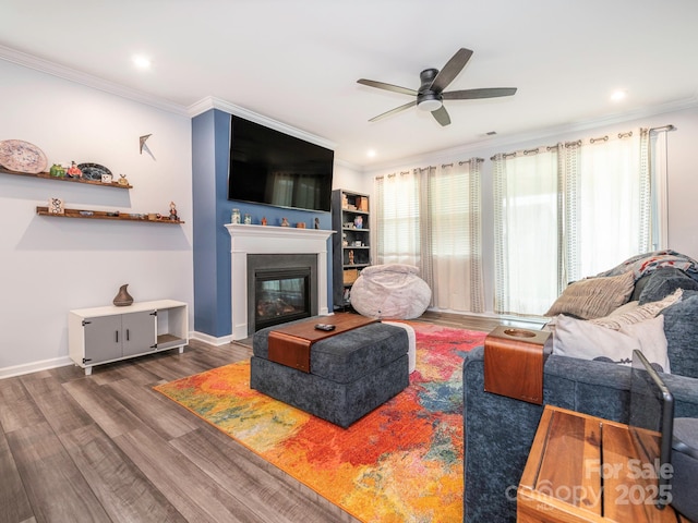 1711 Woodend Dr, Indian Trail, NC 28079 - living room featuring crown molding, a ceiling fan, wood finished floors, a glass covered fireplace, and recessed lighting
