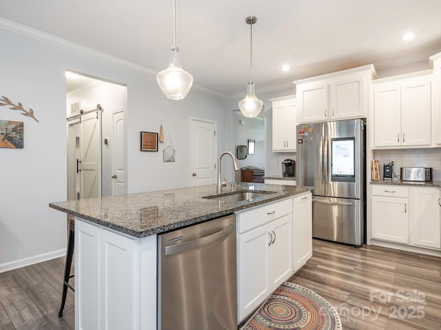 1711 Woodend Dr, Indian Trail, NC 28079 - kitchen with stainless steel appliances, wood finished floors, dark stone countertops, white cabinetry, and ornamental molding