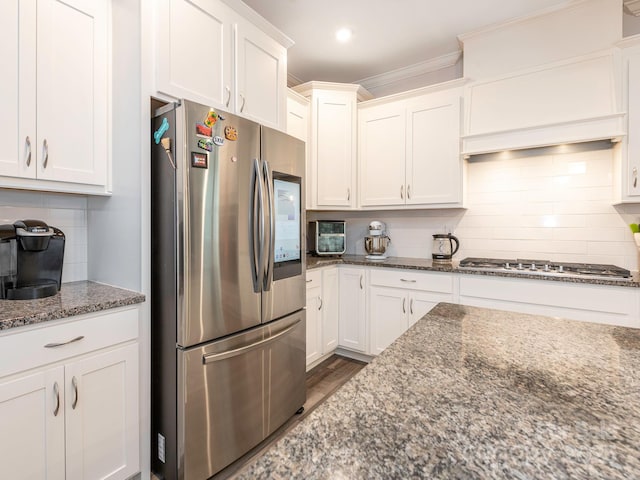 1711 Woodend Dr, Indian Trail, NC 28079 - kitchen with stainless steel appliances, decorative backsplash, white cabinets, dark stone counters, and crown molding
