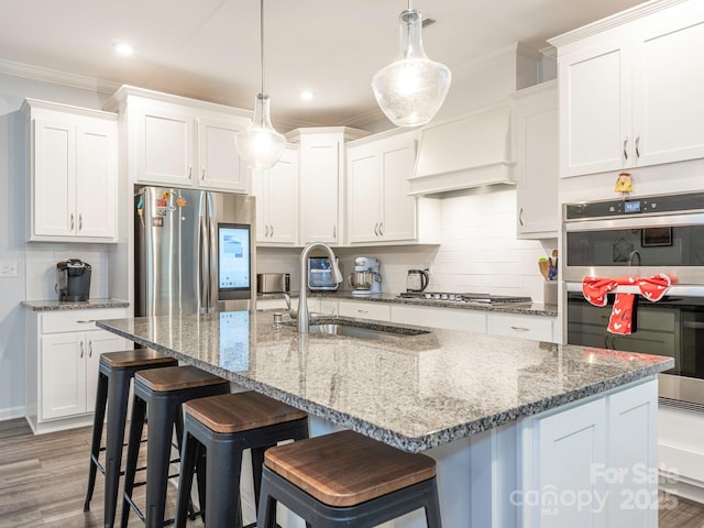 1711 Woodend Dr, Indian Trail, NC 28079 - kitchen with stainless steel appliances, custom range hood, backsplash, ornamental molding, and white cabinetry