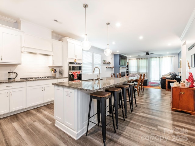 1711 Woodend Dr, Indian Trail, NC 28079 - kitchen featuring crown molding, stainless steel appliances, a ceiling fan, open floor plan, and healthy amount of natural light