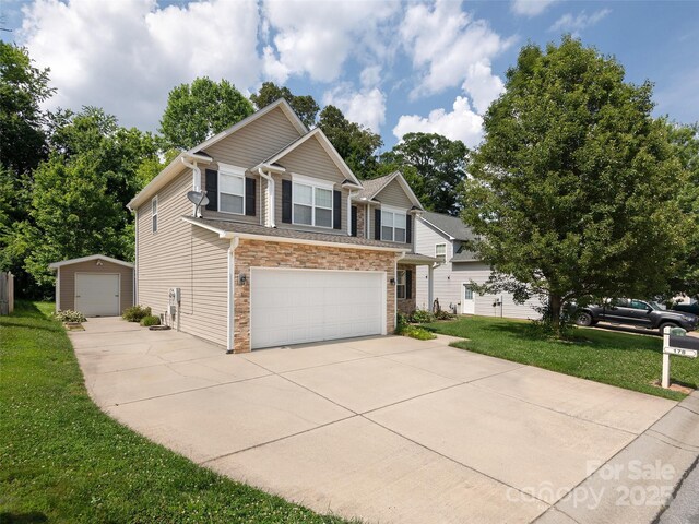 178 Black River Rd, Fletcher, NC 28732 - view of front of home with concrete driveway, a front yard, an attached garage, stone siding, and an outdoor structure