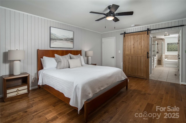 1648 Skyland Dr Unit 77, Seven Devils, NC 28604 - bedroom with wood-type flooring, a barn door, ornamental molding, connected bathroom, and a ceiling fan