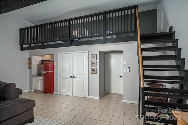 1648 Skyland Dr Unit 77, Seven Devils, NC 28604 - living area featuring light tile patterned flooring, a towering ceiling, and stairway