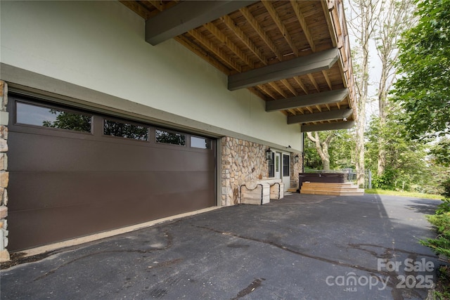 1648 Skyland Dr Unit 77, Seven Devils, NC 28604 - view of patio with a hot tub, a garage, and asphalt driveway