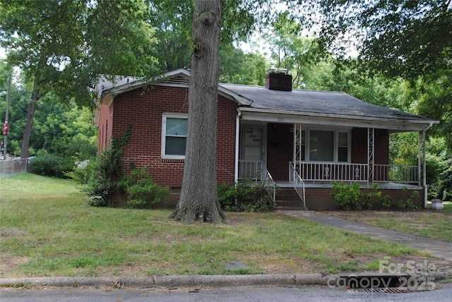 1125 Fries St, Salisbury, NC 28144 - view of front of home with a porch, brick siding, a chimney, and a front yard