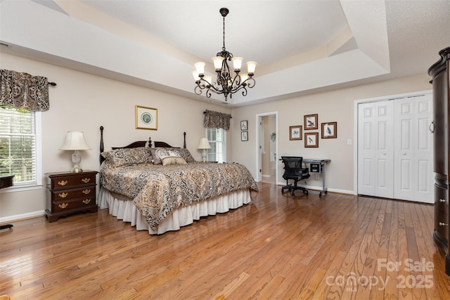 101 Citation Ln, Gastonia, NC 28056 - bedroom with a chandelier, light wood-style flooring, a raised ceiling, and a closet