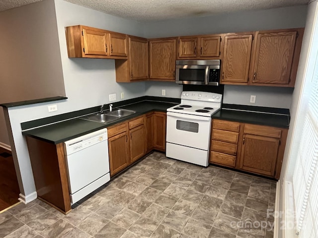 1015 Piney Church Rd, Concord, NC 28025 - kitchen with white appliances, dark countertops, brown cabinets, and a textured ceiling