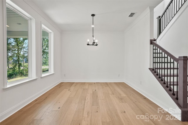 9511 Coast Laurel Ave NW, Concord, NC 28027 - unfurnished dining area featuring a chandelier, light wood-style flooring, stairway, and crown molding