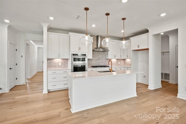 9511 Coast Laurel Ave NW, Concord, NC 28027 - kitchen with wall chimney range hood, stainless steel double oven, backsplash, white cabinetry, and recessed lighting