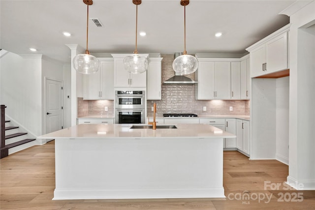 9511 Coast Laurel Ave NW, Concord, NC 28027 - kitchen featuring double oven, wall chimney range hood, gas cooktop, light countertops, and recessed lighting