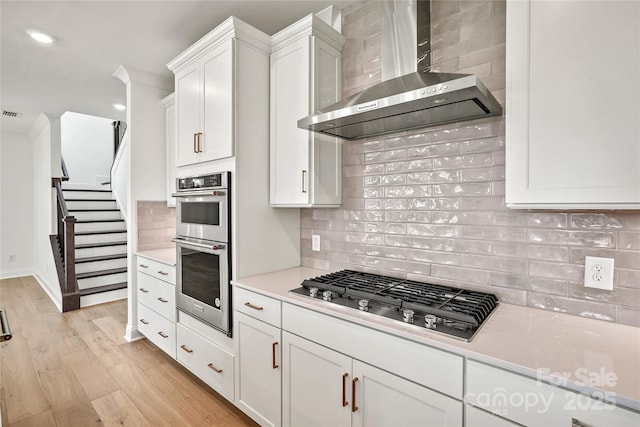 9511 Coast Laurel Ave NW, Concord, NC 28027 - kitchen featuring wall chimney range hood, stainless steel appliances, backsplash, light countertops, and recessed lighting