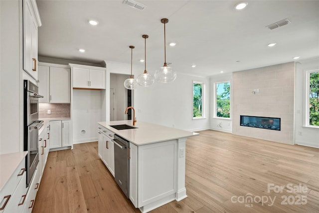 9511 Coast Laurel Ave NW, Concord, NC 28027 - kitchen with dishwasher, light wood-style floors, recessed lighting, light countertops, and white cabinetry
