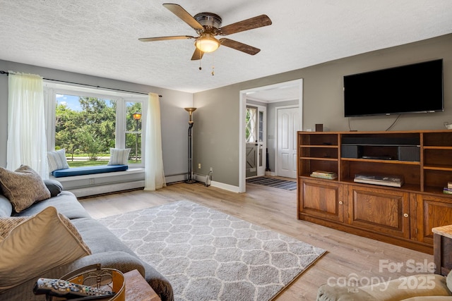 1058 Howard Gap Loop Rd, Flat Rock, NC 28731 - living room featuring a ceiling fan, light wood finished floors, a textured ceiling, and a baseboard heating unit