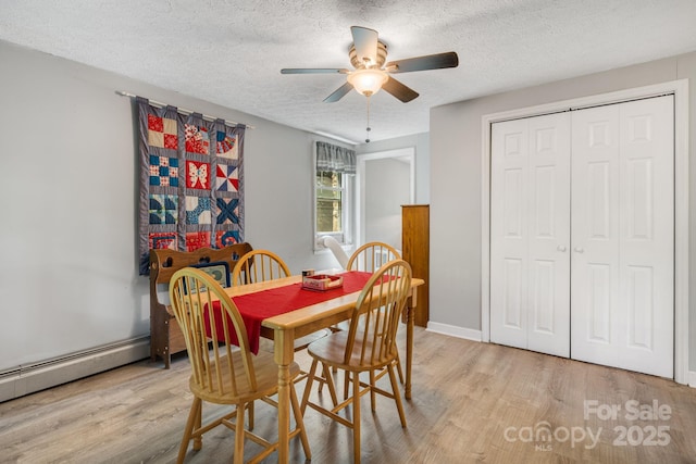 1058 Howard Gap Loop Rd, Flat Rock, NC 28731 - dining space featuring a baseboard radiator, a textured ceiling, light wood finished floors, and ceiling fan