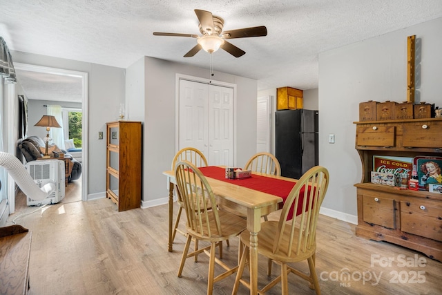 1058 Howard Gap Loop Rd, Flat Rock, NC 28731 - dining room with light wood-style floors, a ceiling fan, and a textured ceiling