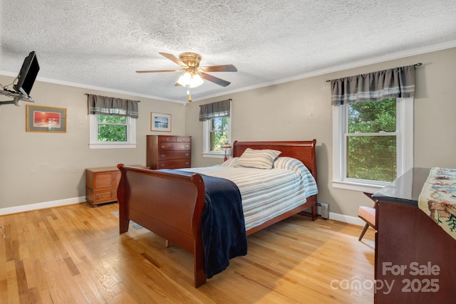 1058 Howard Gap Loop Rd, Flat Rock, NC 28731 - bedroom featuring light wood-style flooring, a baseboard heating unit, ornamental molding, ceiling fan, and a textured ceiling