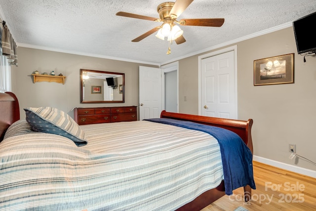 1058 Howard Gap Loop Rd, Flat Rock, NC 28731 - bedroom with wood finished floors, a textured ceiling, a ceiling fan, and ornamental molding