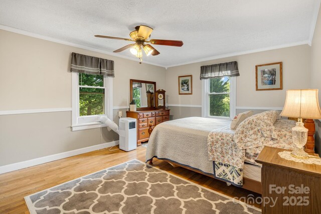 1058 Howard Gap Loop Rd, Flat Rock, NC 28731 - bedroom with wood finished floors, crown molding, and a ceiling fan