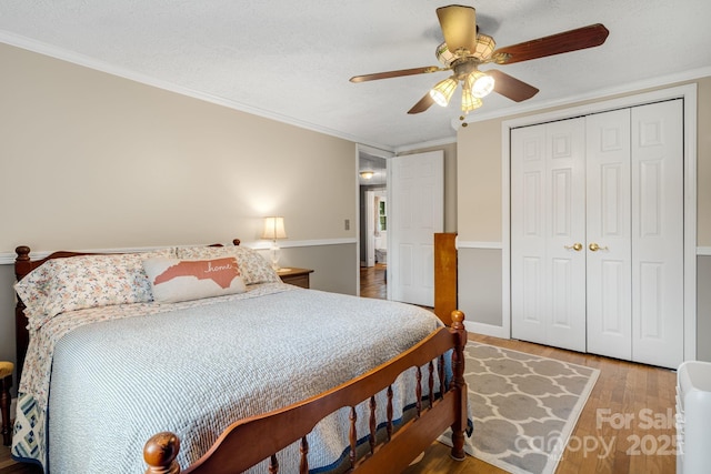 1058 Howard Gap Loop Rd, Flat Rock, NC 28731 - bedroom featuring wood finished floors, a closet, a ceiling fan, and crown molding