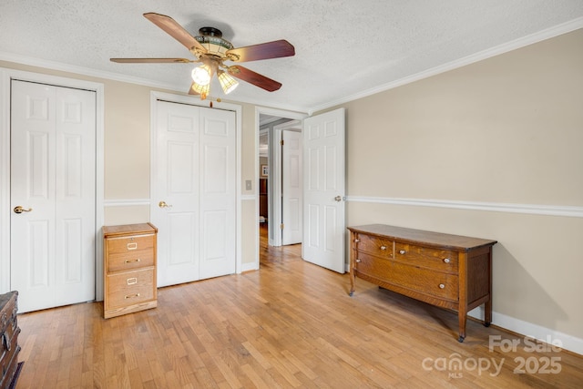 1058 Howard Gap Loop Rd, Flat Rock, NC 28731 - bedroom featuring light wood-type flooring, a textured ceiling, crown molding, multiple closets, and ceiling fan