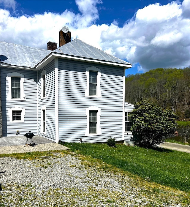 4606 Garvey Bridge Rd, Crumpler, NC 28617 - view of side of home with a chimney, a patio, a yard, and a metal roof