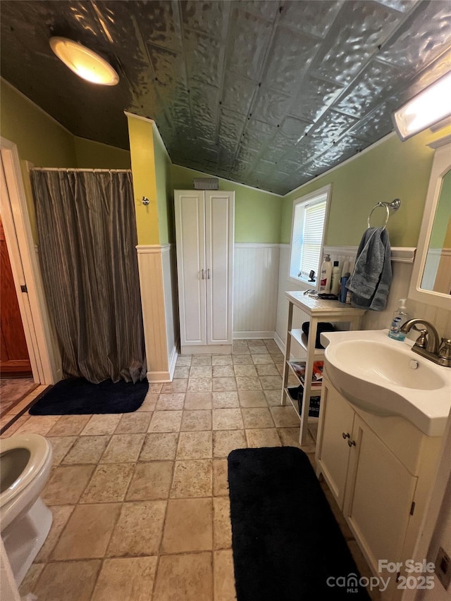 4606 Garvey Bridge Rd, Crumpler, NC 28617 - bathroom featuring vanity, a wainscoted wall, stone tile flooring, vaulted ceiling, and curtained shower