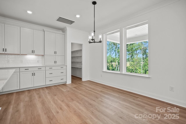 9515 Coast Laurel Ave NW, Concord, NC 28027 - kitchen with a chandelier, light wood-style flooring, light countertops, backsplash, and recessed lighting