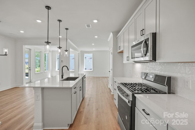 9515 Coast Laurel Ave NW, Concord, NC 28027 - kitchen featuring stainless steel appliances, light wood-type flooring, tasteful backsplash, recessed lighting, and a center island with sink