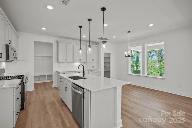 9515 Coast Laurel Ave NW, Concord, NC 28027 - kitchen with appliances with stainless steel finishes, light countertops, light wood-style flooring, an island with sink, and recessed lighting