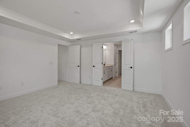 9515 Coast Laurel Ave NW, Concord, NC 28027 - unfurnished bedroom featuring a tray ceiling, recessed lighting, light colored carpet, and ensuite bathroom