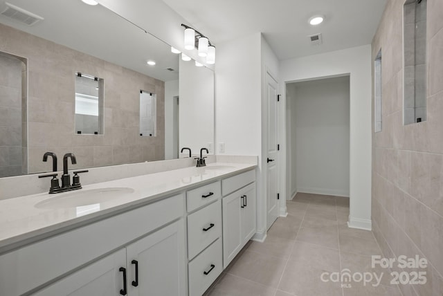 9515 Coast Laurel Ave NW, Concord, NC 28027 - full bath featuring tile patterned flooring, double vanity, tile walls, and recessed lighting