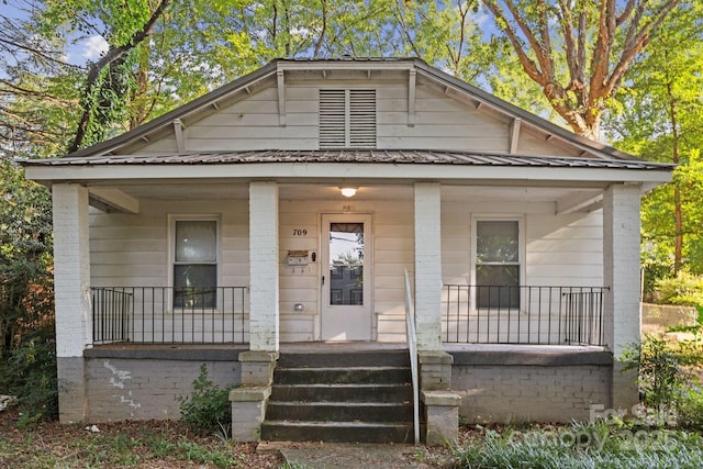 709 E Front St, Statesville, NC 28677 - bungalow-style house with covered porch, a metal roof, and brick siding